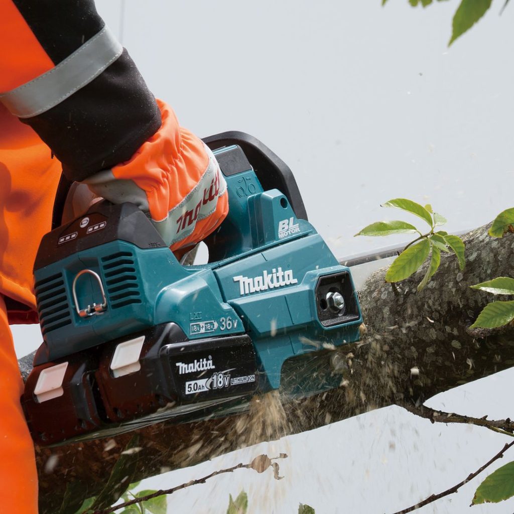 MAKITA Ketjusaha LXT. Kuvassa henkilö sahaamassa puun runkoa Ketjusaha LXT:n avulla.