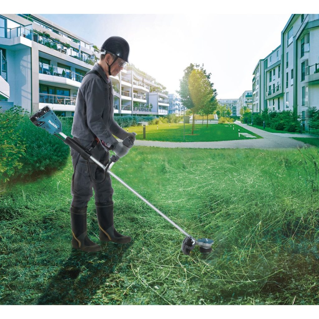MAKITA Siimaleikkuri LXT. Kuvassa henkilö trimmaamassa nurmikkoa Siimaleikkuri LXTn avulla.