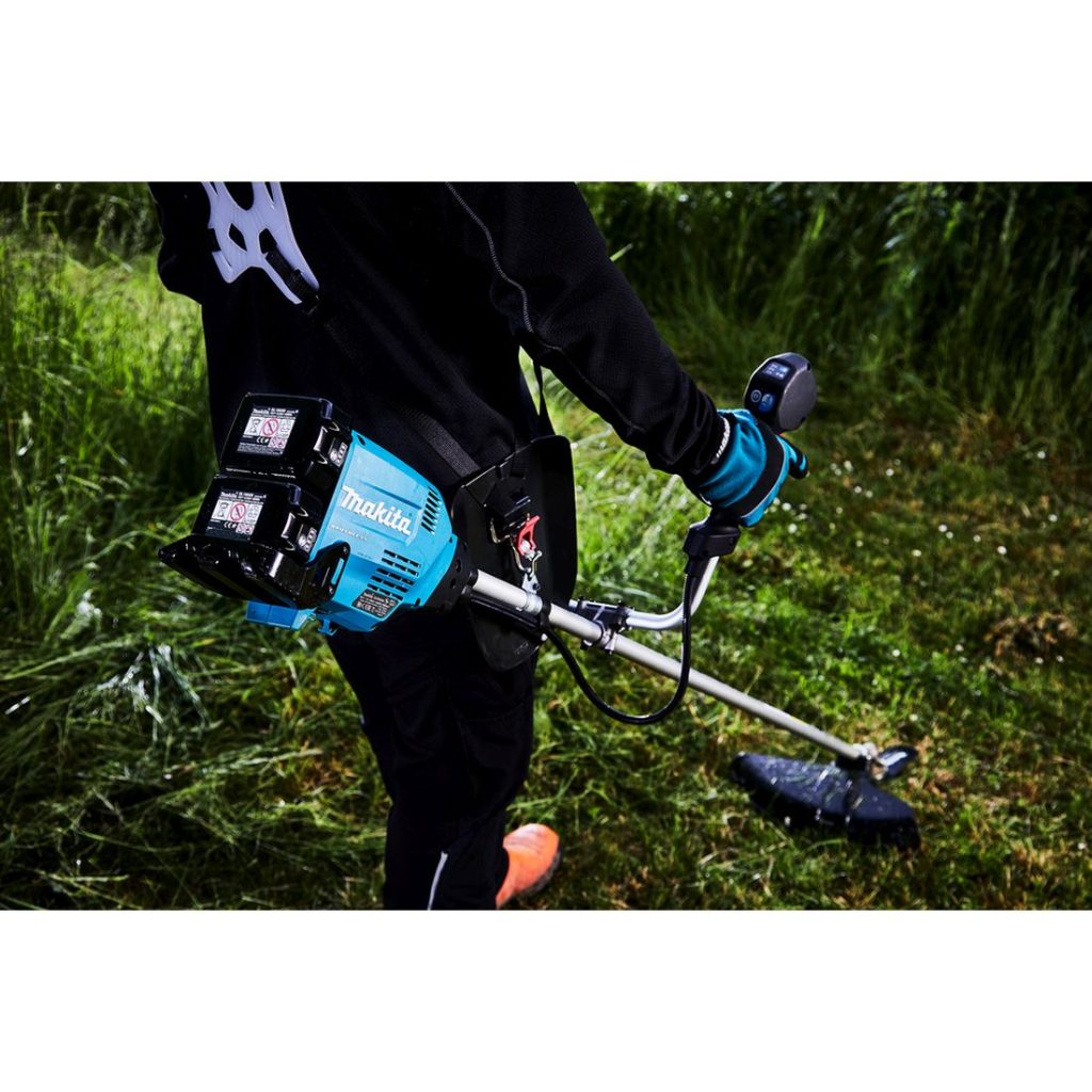 MAKITA Ruohoraivuri LXT. Kuvassa henkilö trimmaamassa nurmikkoa Ruohoraivuri LXT:n avulla.