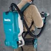MAKITA Reppuimuri LXT. Kuvassa henkilö poraamassa betoniseinään akkuporavasaralla Reppuimuri LXT liitettynä akkuporavasaraan.
