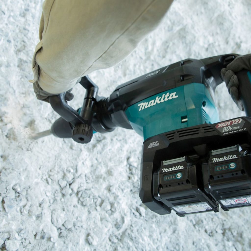 MAKITA Piikkausvasara XGT. Kuvassa henkilö piikkaamassa kiviseinää Piikkausvasara XGT:n avulla.