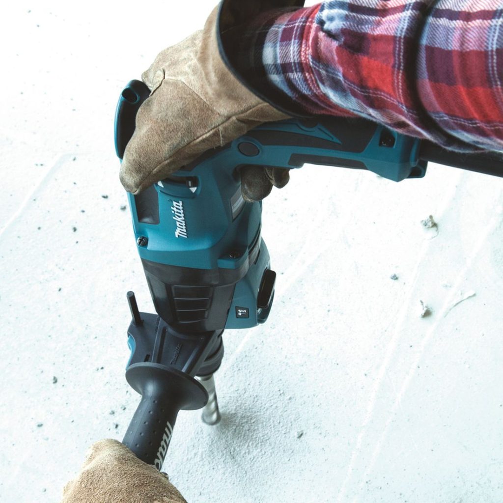 MAKITA Poravasara. Kuvassa henkilö poraamassa reikää betoniin poravasaran avulla.