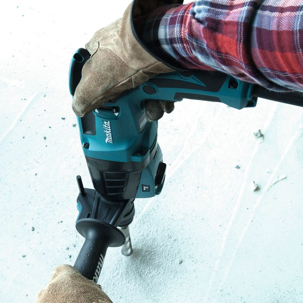 MAKITA Poravasara. Kuvassa henkilö poraamassa reikää betoniin poravasaran avulla.