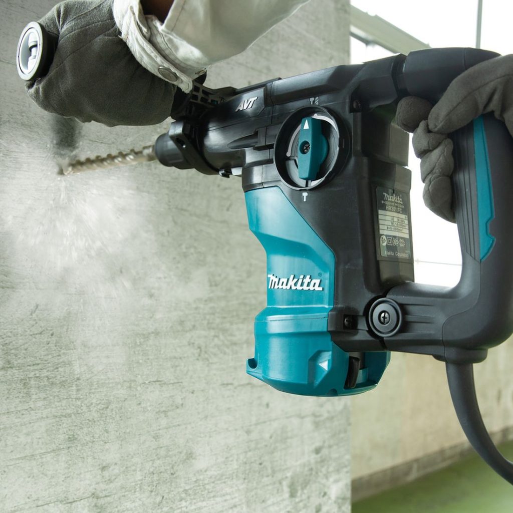 MAKITA Poravasara. Kuvassa henkilö poraamassa reikää betoniseinään poravasaran avulla.