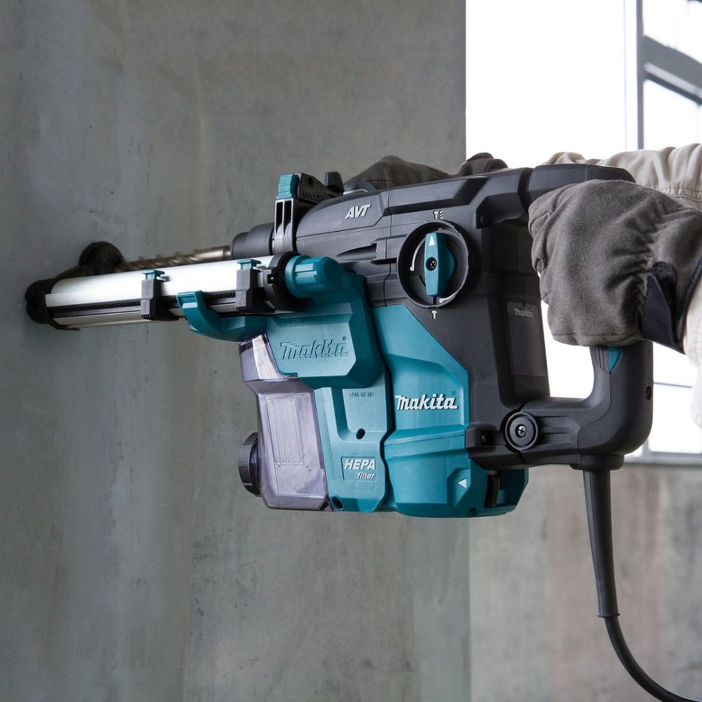 MAKITA Poravasara. Kuvassa henkilö poraamassa reikää betoniseinään poravasaran avulla.