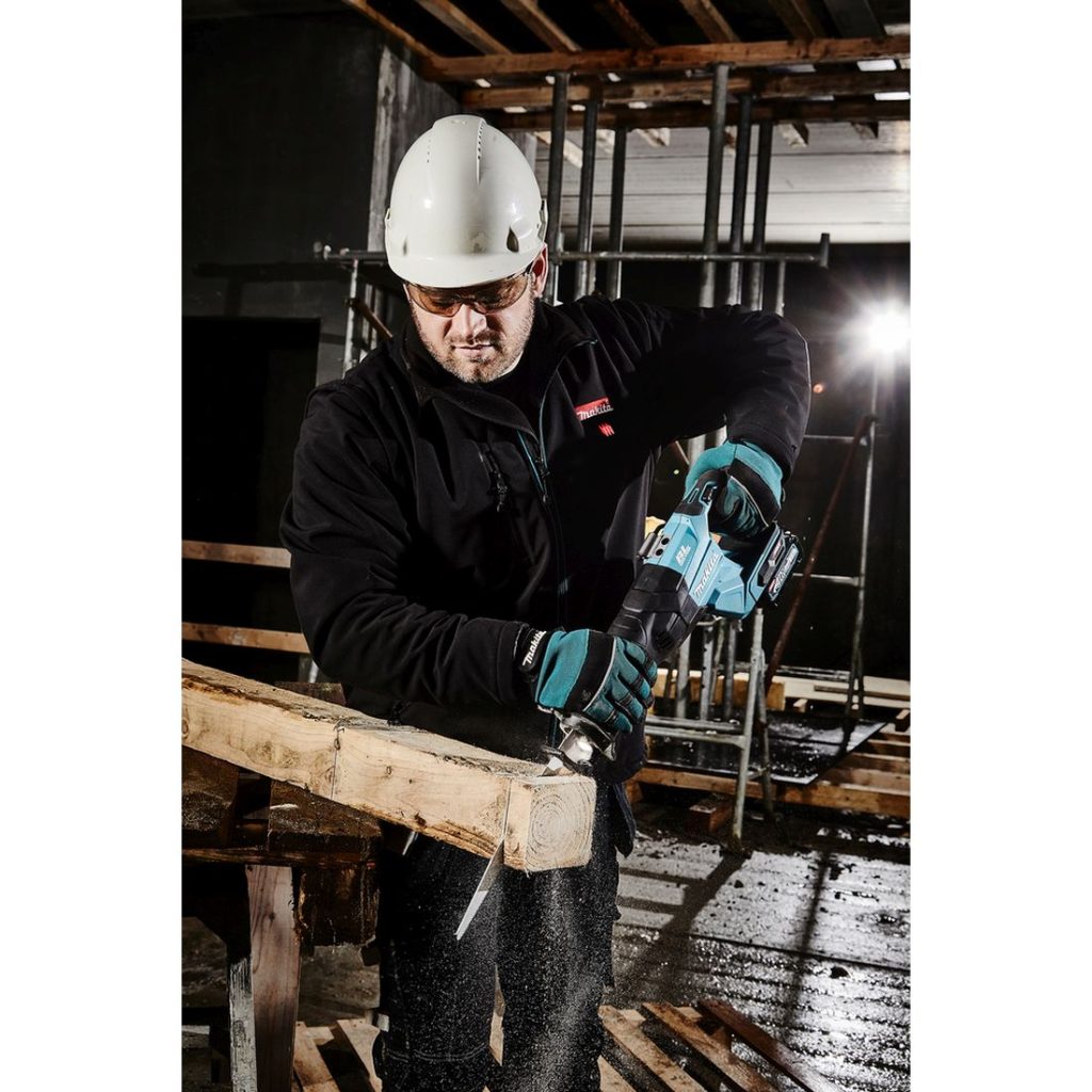MAKITA Puukkosaha XGT. Kuvassa henkilö katkaisemassa puutolppaa Puukkosaha XGT:n avulla.
