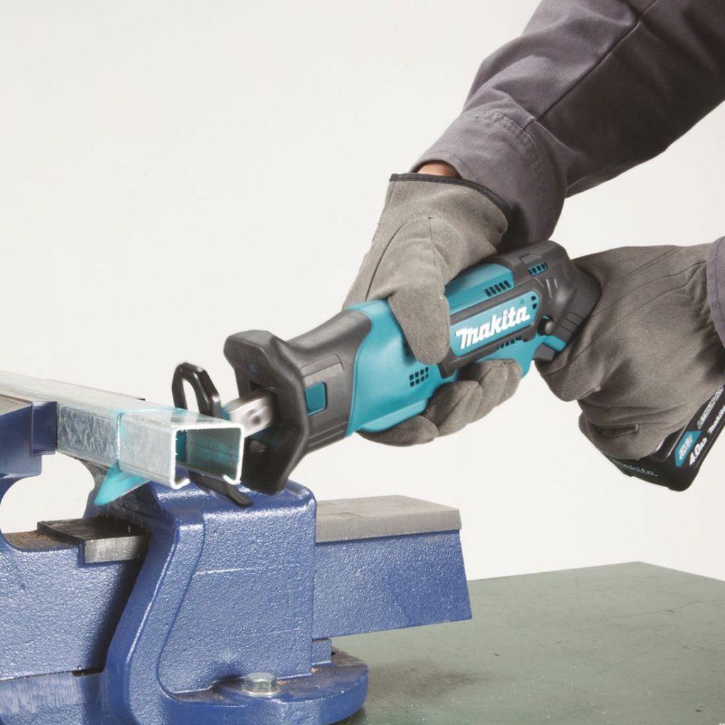 MAKITA Puukkosaha CXT. Kuvassa henkilö katkaisemassa U-profiilia Puukkosaha CXT:n avulla.