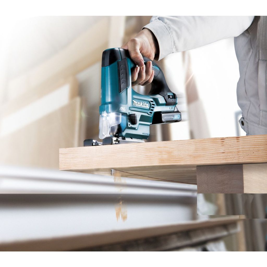 MAKITA Pistosaha CXT. Kuvassa henkilö kaventamassa pöytätasoa pistosaha CXT:n avulla.