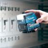 MAKITA LED-valaisin XGT. Kuvassa henkilö pimeässä valaisemassa sähkökaappia LED-valaisin XGT:n avulla.