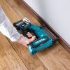 MAKITA Pinninaulain XGT. Kuvassa henkilö naulaamassa lattialistaa seinään Pinninaulain XGT:n avulla.