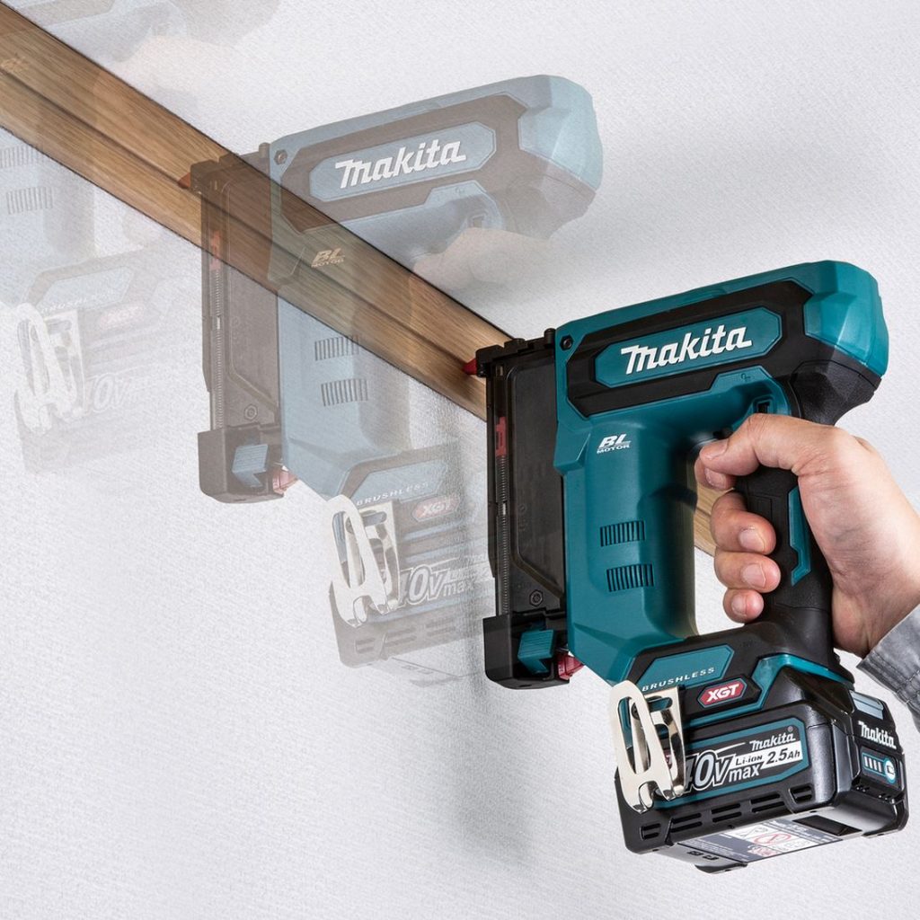 MAKITA Pinninaulain XGT. Kuvassa henkilö naulaamassa kattolistaa seinään Pinninaulain XGT:n avulla.