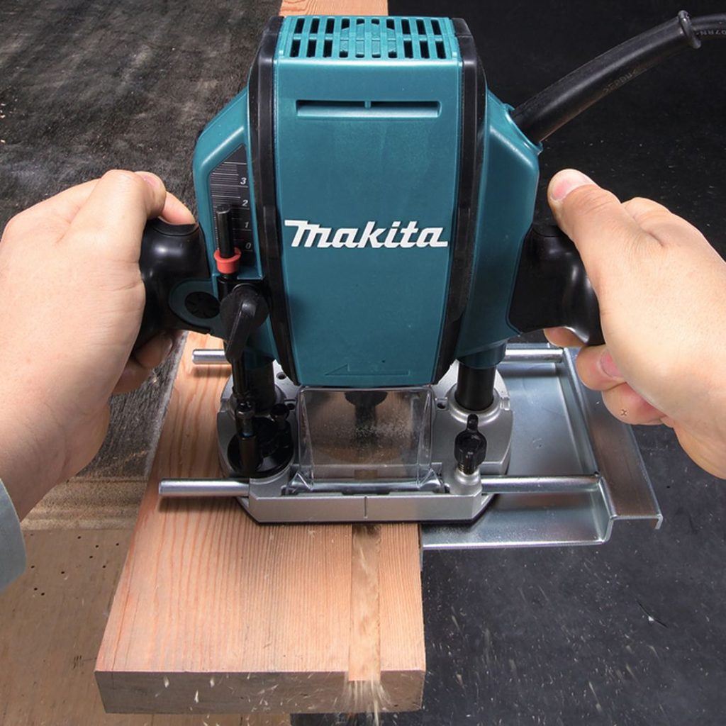 MAKITA Yläjyrsin. Kuvassa henkilö jyrsimässä roiloa höylättyyn puukappaleeseen yläjyrsimen avulla.