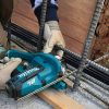 MAKITA Kierretankoleikkuri CXT. Kuvassa henkilö katkaisemassa kierretankoa valutyömaalla Kierretankoleikkuri CXT:n avulla.