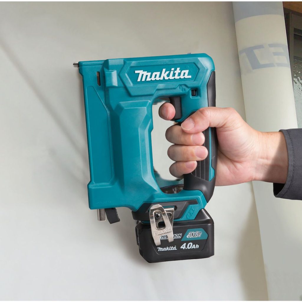 MAKITA Nitoja CXT. Kuvassa henkilö nitomassa rakennusmuovia työmaalla Nitoja CXT:n avulla.