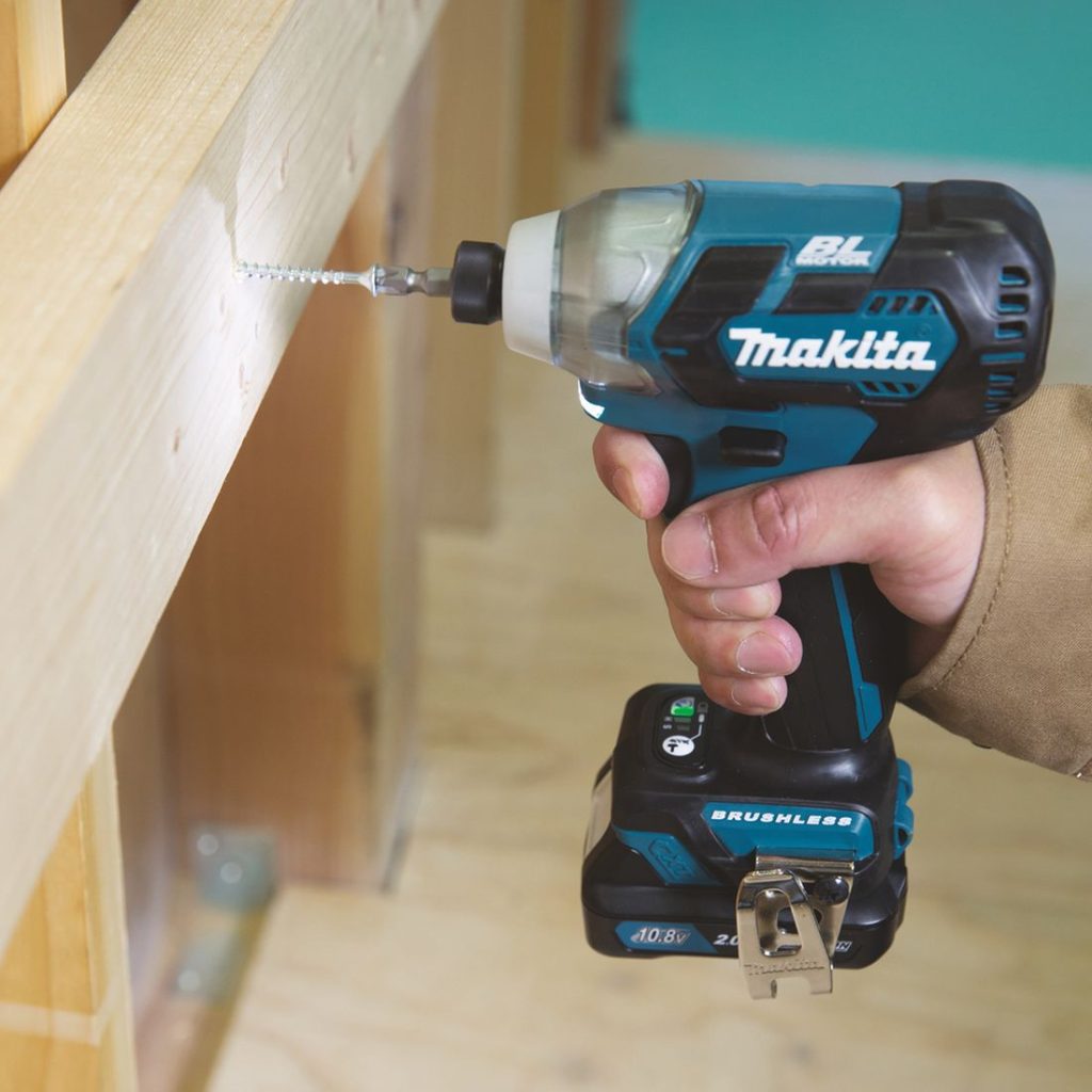 MAKITA Iskevä ruuvinväännin CXT. Kuvassa henkilö ruuvaamassa ruuvia runkopuuhun iskevän ruuvinväännin CXT:n avulla.