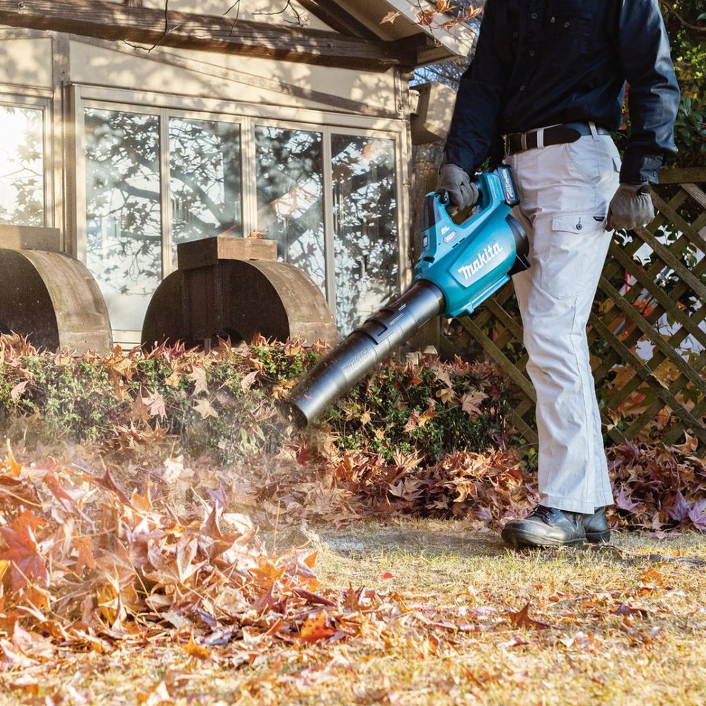 MAKITA Puhallin XGT. Kuvassa henkilö puhaltamassa lehtiä Puhallin XGT:n avulla.