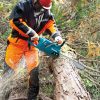 MAKITA Ketjusaha XGT. Kuvassa henkilö katkaisemassa kaadettua puuta Ketjusaha XGT:n avulla.