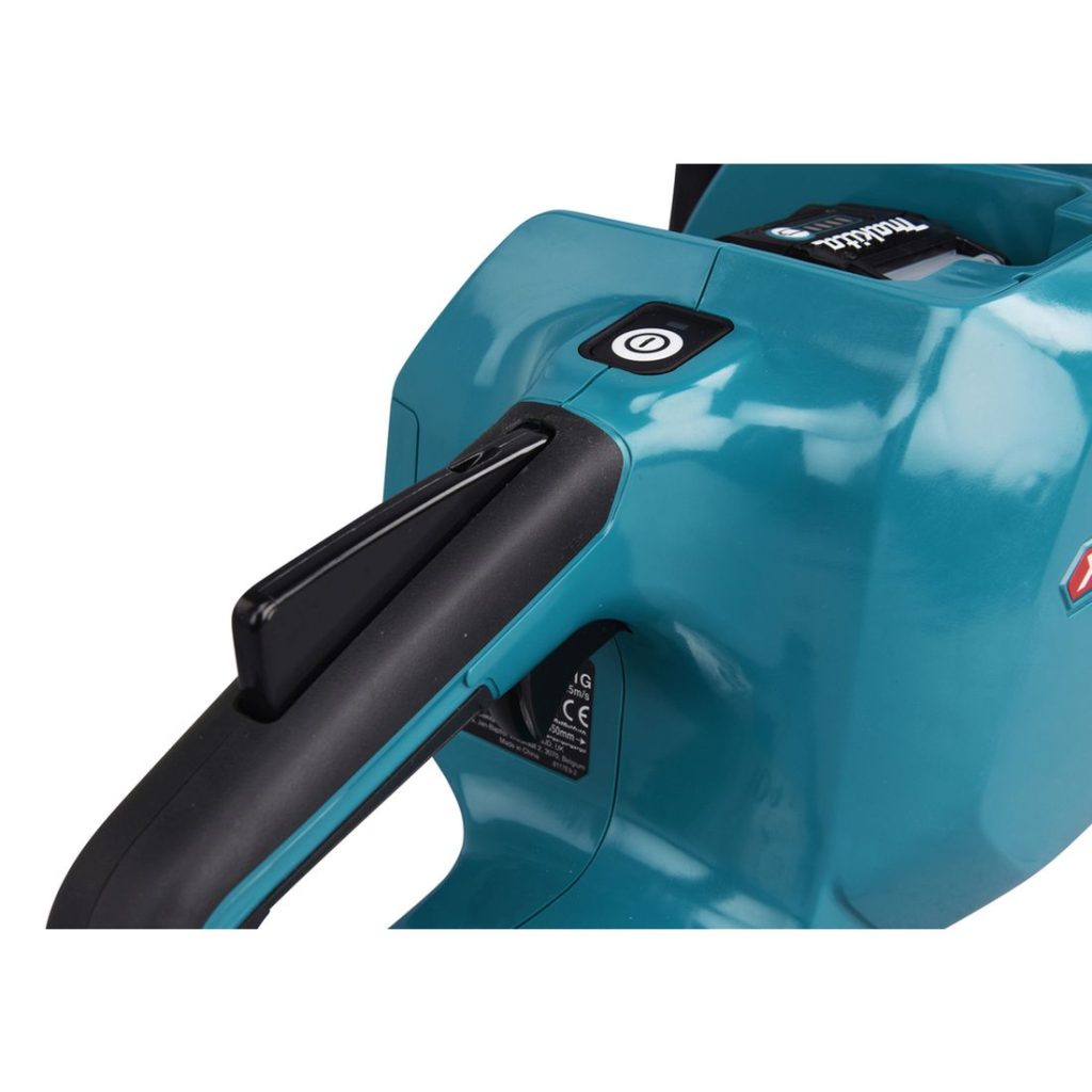 MAKITA Ketjusaha XGT. Lähikuvassa Ketjusaha XGT:n virtakytkin.