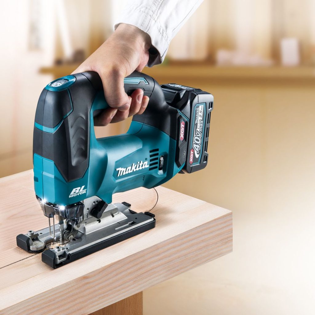 MAKITA Pistosaha XGT. Kuvassa henkilö sahaamassa soikeaa reikää paksuun lankkuun Pistosaha XGT:n avulla.