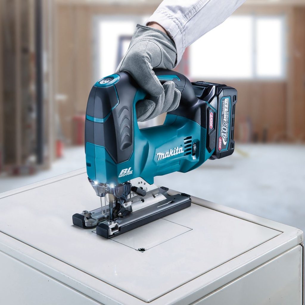 MAKITA Pistosaha XGT. Kuvassa henkilö sahaamassa neliön muotoista reikää peltikoteloon Pistosaha XGT:n avulla.