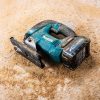 MAKITA Pistosaha XGT. Kuvassa Pistosaha XGT puisen lankun päällä kyljellään sahanpurun peittämänä.