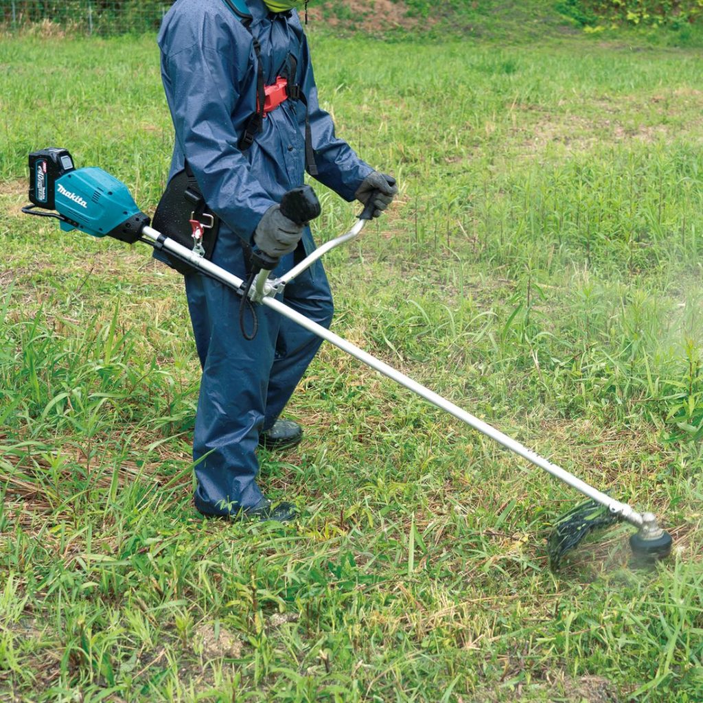 MAKITA Ruohoraivuri XGT. Kuvassa henkilö leikkaamassa nurmikkoa Ruohoraivuri XGT:n avulla.