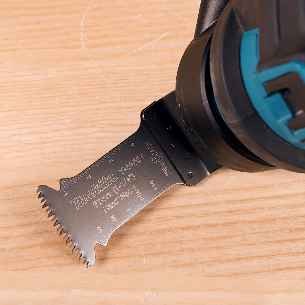 MAKITA Sahanterä, upotukseen, leveys 32mm. Kuvassa sahanterä asennettuna monitoimikoneeseen laudan päällä.