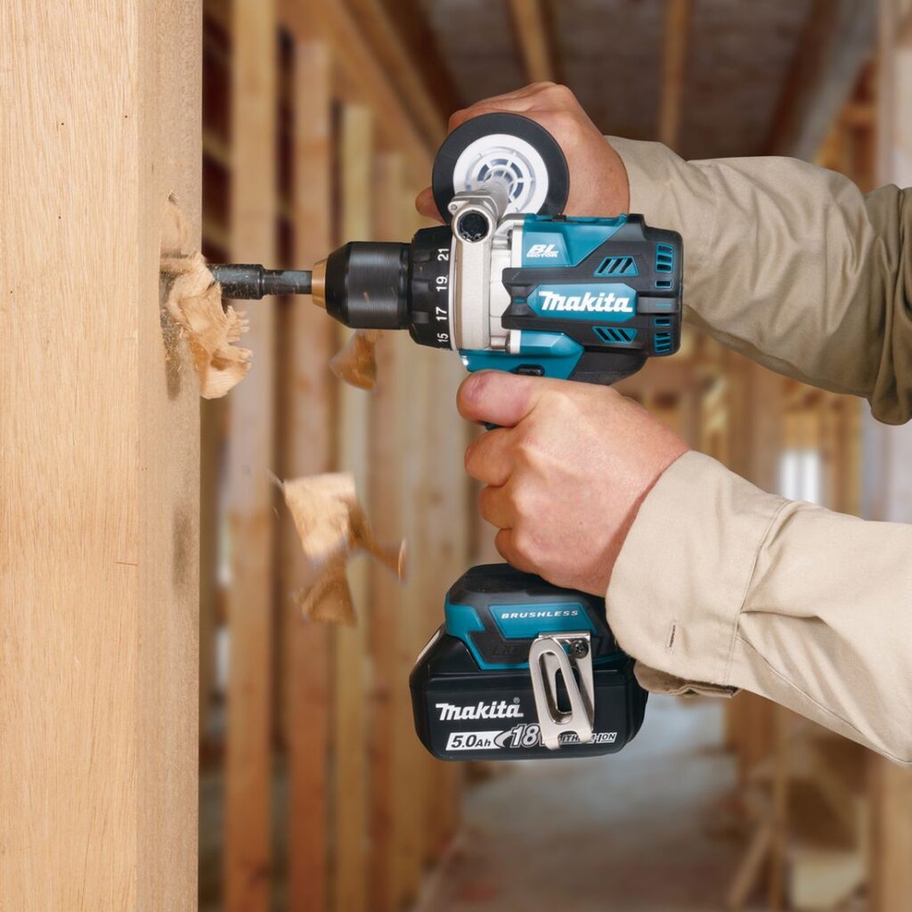 MAKITA Porakone LXT. Kuvassa henkilö poraamassa runkopuuhun reikää porakone LXT:n avulla.