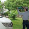 MAKITA Akkupainepesuri LXT. Kuvassa henkilö pesemässä autoa akkupainepesurin avulla.