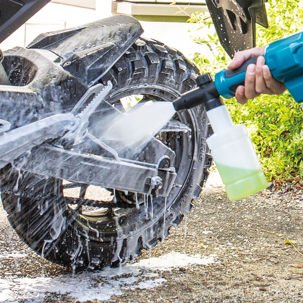 MAKITA Akkupainepesuri LXT. Kuvassa henkilö pesemässä autoa akkupainepesurin avulla.