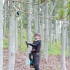 MAKITA Kulma-adapteri varrellisille ketjusahoille UA003G, UA004G, DUA301. Kuvassa Kulma-adapteri varrellisille ketjusahoille UA003G, UA004G, DUA301. Kuvassa henkilö sahaamassa puun oksia korkealta kulma-adapteria hyväksi käyttäen.